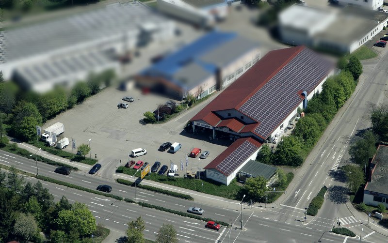 Luftbild des Betriebsgeländes in der Gottlieb-Daimler-Straße mit Parkflächen und Photovoltaikdach